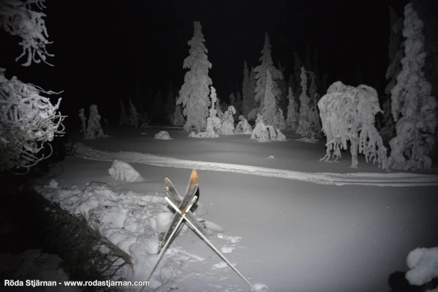 Ett par Vita Blixten träskidor mot snön en kall vinternatt